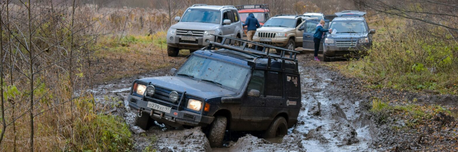 A photograph of several Jeeps that can't go anywhere because one is stuck in the mud
